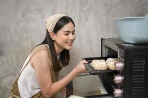 belle jeune femme cuisine dans sa cuisine, sa boulangerie et son café photo