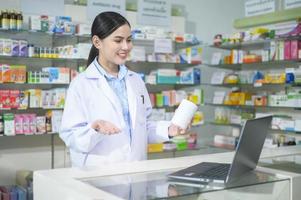 une pharmacienne conseillant une cliente par appel vidéo dans une pharmacie de pharmacie moderne. photo