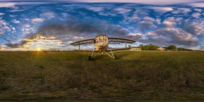 panorama hdri sphérique complet et harmonieux vue d'angle à 360 degrés parmi les champs près du vieil avion au coucher du soleil d'été avec des nuages impressionnants en projection équirectangulaire, prêt pour la réalité virtuelle vr ar photo