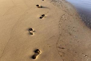 empreintes de pas dans le sable sur la plage de la ville. photo