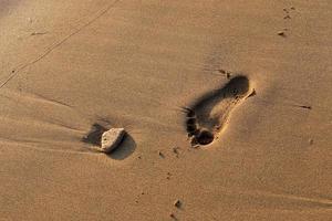 empreintes de pas dans le sable sur la plage de la ville. photo