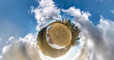 transformation de la petite planète avec courbure de l'espace. vue aérienne panoramique sphérique à 360 sur la rive du lac en été ensoleillé avec des nuages impressionnants. photo