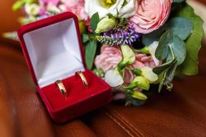 bouquet de mariage lumineux de roses roses blanches d'été et d'orchidées avec des fleurs sauvages violettes avec des anneaux de mariage photo