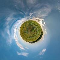 transformation de la petite planète du panorama sphérique à 360 degrés. vue aérienne abstraite sphérique dans le champ dans une belle soirée avec de beaux nuages impressionnants. courbure de l'espace. photo