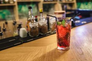 Cocktail d'alcool rouge prêt sur des barres d'arrière-plan d'épices dans un bar d'élite pour faire des cocktails cannelle rose musquée clou de girofle cerise ivre photo