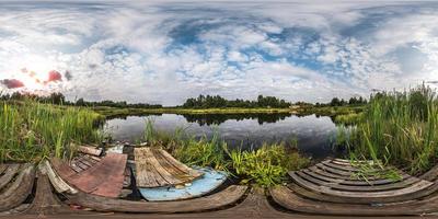 panorama sphérique complet et harmonieux 360 par 180 angle de vue sur le rivage avec des ordures de petit lac en soirée d'été ensoleillée avec des nuages impressionnants en projection équirectangulaire, contenu de réalité virtuelle skybox vr photo