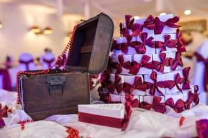 coffre en bois sur la table avec une nappe violette et de petits cadeaux pour les invités des jeunes mariés photo