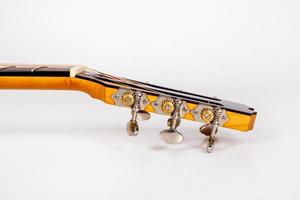 Chevilles de réglage sur tête de machine en bois de guitare six cordes sur fond blanc photo
