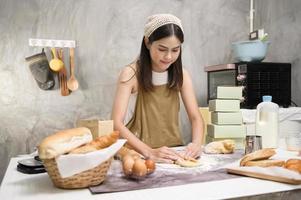 belle jeune femme cuisine dans sa cuisine, sa boulangerie et son café photo