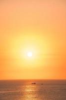 beau paysage de plage au coucher du soleil, nature exotique de l'île tropicale, ciel rouge jaune coloré, bateau silhouette, reflet doré du soleil, vacances d'été. cinématique de nuage de ciel. photo