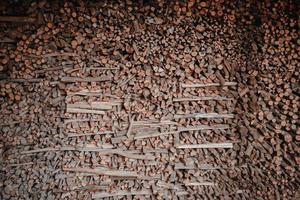 grumes de pin fraîchement coupées en tas de bois à l'usine de scierie. grande pile de troncs d'arbres à la scierie de production de bois. traitement du bois dans un entrepôt de construction en bois. souches de bois de chauffage hachées. sylviculture photo