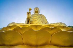 la main de la statue de bouddha doré tenant le lotus au monastère de chon khong. photo