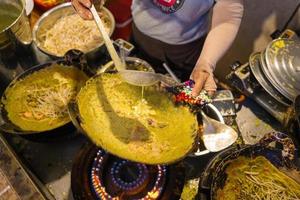 des crêpes banh xeo vietnamiennes remplies de porc ou de poulet peuvent également, des crevettes, des oignons et des germes de soja, et de la sauce piquante placée près de l'assiette sur la table photo