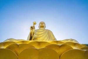 la main de la statue de bouddha doré tenant le lotus au monastère de chon khong. photo