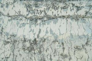 texture du vieux mur de béton gris pour le fond. texture rugueuse sur le mur gris forme rugueuse due à l'écaillage de la couche de peinture due à la pluie. photo