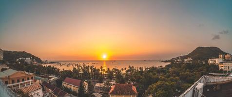 vue aérienne de la ville de vung tau avec un beau coucher de soleil et tant de bateaux. vue panoramique sur la côte vung tau d'en haut, avec vagues, littoral, rues, cocotiers et montagne tao phung au vietnam.