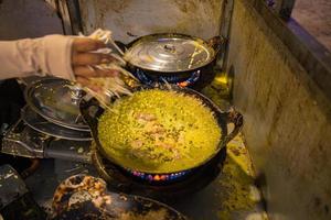 des crêpes banh xeo vietnamiennes remplies de porc ou de poulet peuvent également, des crevettes, des oignons et des germes de soja, et de la sauce piquante placée près de l'assiette sur la table photo