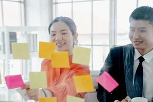 des gens créatifs heureux faisant une carte mentale sur un mur de verre au bureau. photo