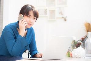 belle jeune femme d'affaires asiatique excitée et heureuse de réussir à travailler avec un ordinateur portable, une fille prenant un téléphone intelligent mobile et un café de travail, concept d'entreprise indépendante de carrière. photo