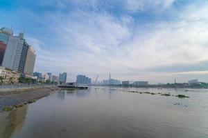 ho chi minh ville, vietnam - 12 février 2022 skyline avec le gratte-ciel historique 81, un nouveau pont à haubans est en train de construire reliant la péninsule de thu thiem et le district 1 de l'autre côté de la rivière saigon. photo