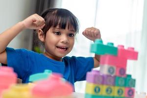 adorable petite fille jouant des blocs de jouets dans une pièce lumineuse photo