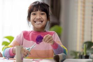 portrait d'une petite fille asiatique coupant un papier dans des activités sur le cours de bricolage à l'école.ciseaux coupent du papier. photo