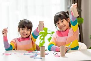 portrait d'une petite fille asiatique coupant un papier dans des activités sur le cours de bricolage à l'école.ciseaux coupent du papier. photo