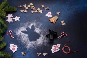 Biscuits de pain d'épice faits maison de noël sur une table en béton foncé photo