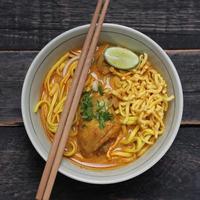 recette de khao soi, khao soi, khao soi kai, nouilles thaïlandaises khao soi, curry de poulet avec assaisonnement servi sur table en bois photo