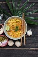 recette de khao soi, khao soi, khao soi kai, nouilles thaïlandaises khao soi, curry de poulet avec assaisonnement servi sur table en bois