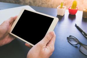 gros plan des mains masculines à l'aide d'un gadget d'ordinateur tactile tablette sur le bureau photo