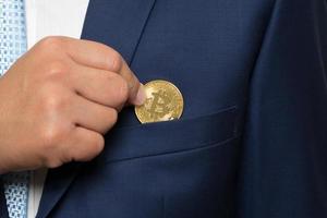 homme d'affaires en costume tenant un bitcoin doré photo