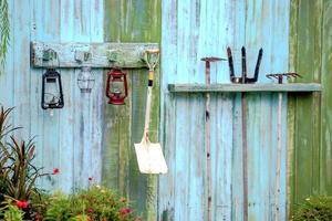 équipement de jardinage suspendu à un mur en bois de couleur bleue. photo