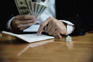 homme d'affaires montrer de l'argent billet de banque faire un plan financier inviter les gens à vendre ou acheter une maison et une voiture - propriétés monétaires prêt assurance crédit concept photo