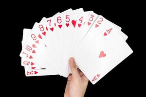 main tenant des cartes à jouer isolées sur fond noir. photo