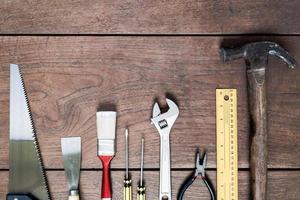 de nombreux outils sur fond de table en bois. photo
