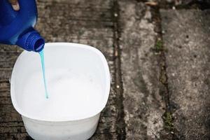 l'homme prépare de l'eau de shampoing pour laver la voiture en utilisant - les gens à la maison concept de nettoyage de voiture photo