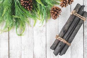 vue de dessus du sapin avec des pommes de pin et du bois de chauffage sur une table en bois, fond de décoration de noël photo