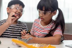 deux enfants asiatiques s'amusant à apprendre à coder ensemble, à apprendre à distance à la maison, à la science des tiges, à l'enseignement à domicile, à la distanciation sociale amusante, à l'isolement, au nouveau concept normal photo