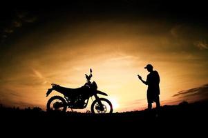 silhouettes masculines et vélos de motocross de tourisme. parc pour se détendre à la montagne le soir. concept de voyage d'aventure et de loisirs photo