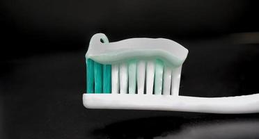 brosse à dents et dentifrice sur fond noir photo