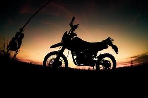 parc de silhouette de motocross moto touristique sur la montagne le soir. concept de voyage d'aventure photo