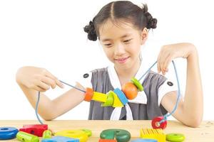 jolie fille asiatique joue un jouet en bois coloré photo