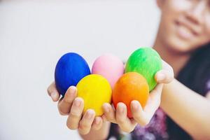 enfant montrant joyeusement des oeufs de pâques colorés - concept de célébration de vacances de pâques photo