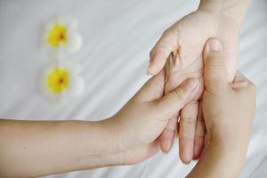 massage spa des mains sur fond de lit blanc propre - les gens se détendent avec un service de massage des mains photo