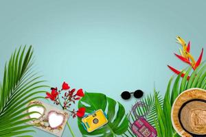 composition d'accessoires pour le concept d'été avec des feuilles de palmier tropical sur fond bleu pastel, vue de dessus et espace de copie photo