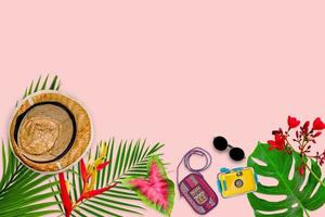 composition d'accessoires pour le concept d'été avec des feuilles de palmier tropical sur fond rose pastel, vue de dessus et espace de copie photo
