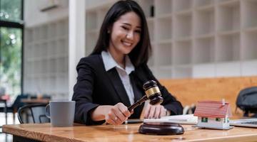 femme d'affaires ou avocats travaillant sur un bureau en bois au bureau. droit, services juridiques, conseils, vente aux enchères de juge et concept immobilier. photo