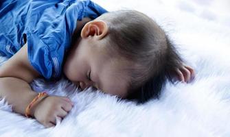 un beau bébé de 6 mois avec de grands yeux se trouve sur le lit. photo