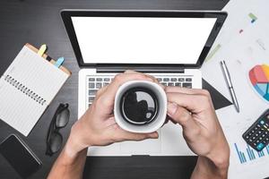 vue de dessus du lieu de travail avec ordinateur portable et document, mains masculines tenant une tasse de café, concepts d'analyse commerciale, rapport financier et stratégie.